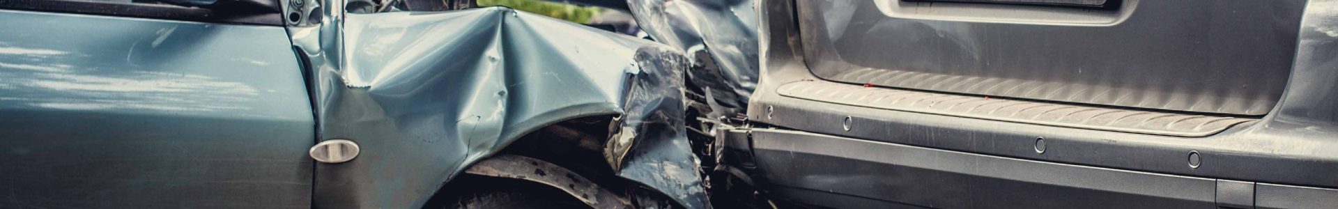 Close up smached cars on a road. Image of a auto accident involving two cars.